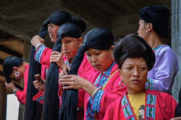 Tribal Zhuang women are brushing their long hair at Pingan Longshen